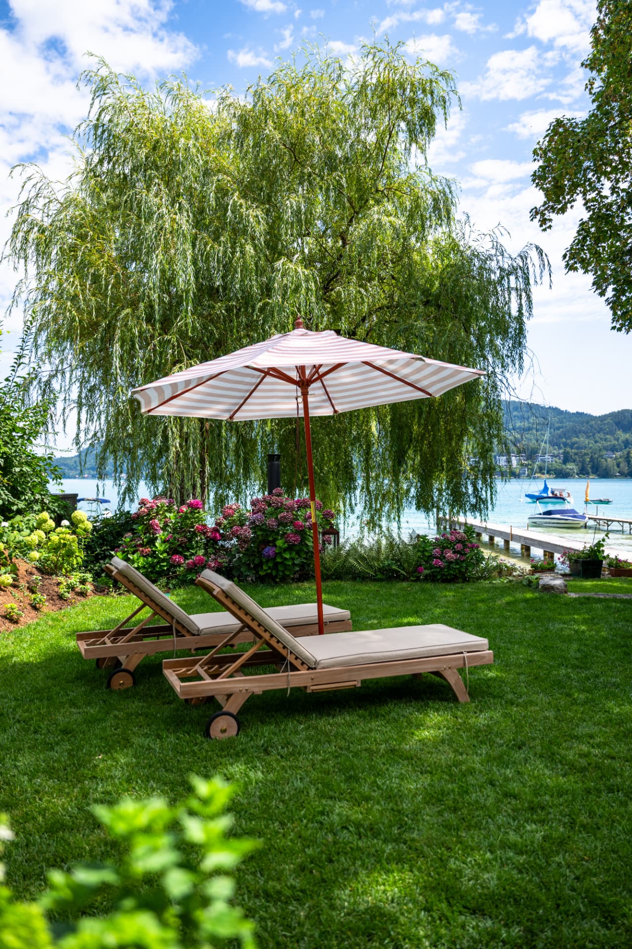 Zwei Liegestühle unter der alten Weide mit Blick auf den Wörthersee